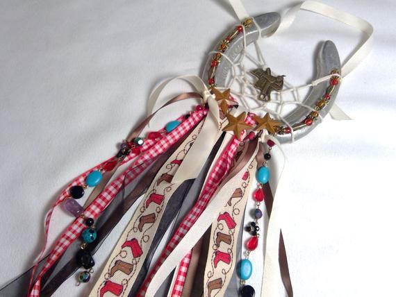 an assortment of hair ties are arranged on a white surface with beads and charms hanging from them