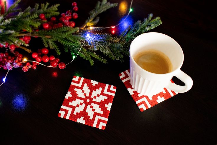 a cup of coffee sitting on top of a wooden table next to a christmas tree