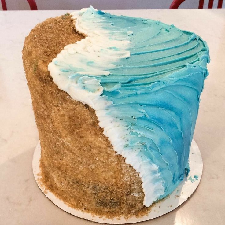 a blue and white frosted cake sitting on top of a table