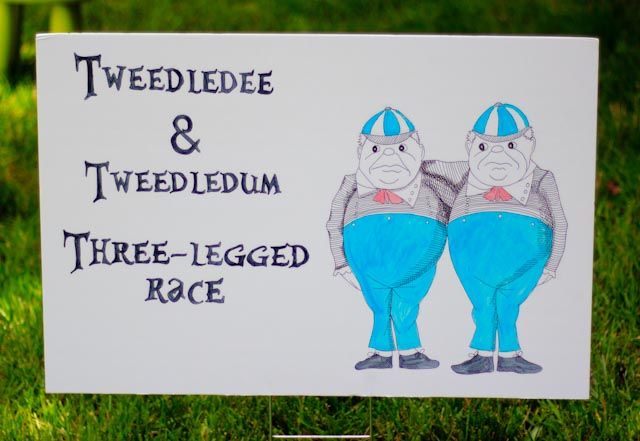 a sign on the grass that says weddlee and tweededium three - legged race