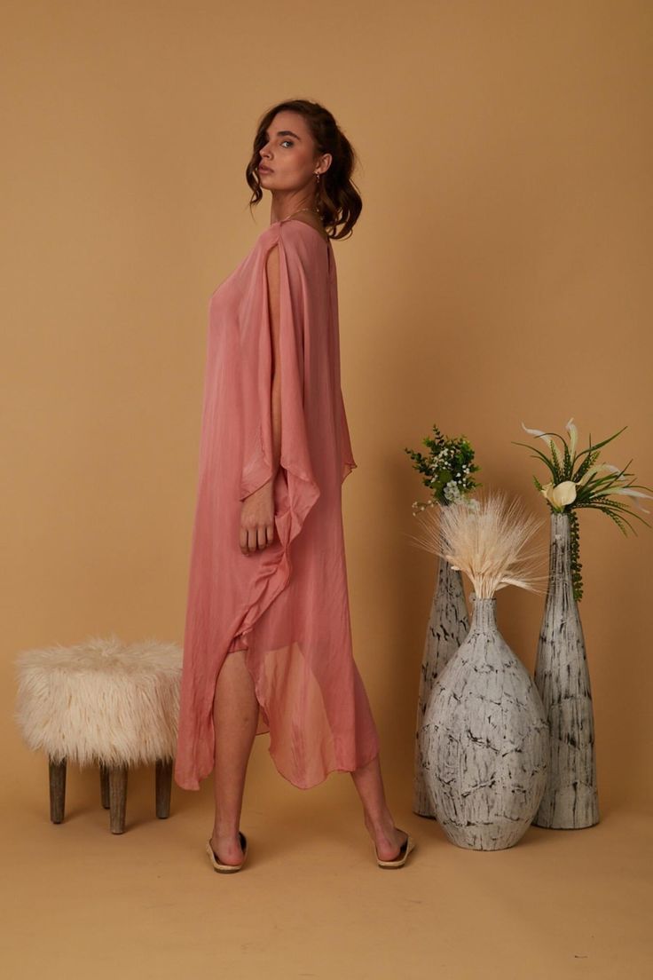 The SHARRA Dress is an Italian-inspired silk tunic perfect for a special event with friends or an evening out with someone special. With a scoop neck and open, flowy sleeves that split at the shoulder, it is the right dress for the goddess at heart. - Lined to the knees - Flowy sleeves - Scoop neckline - Italian silk Size Guide Chic Flowy Silk Dress, Chic Long Tunic For Spring, Chic Silk Satin Dress For Brunch, Elegant Long Rayon Dresses, Long Silk Dresses For Daywear, Elegant Silk V-neck Tunic, Elegant Viscose Kaftan, Elegant Dresses With Kimono Sleeves For Daywear, Elegant Daywear Dresses With Kimono Sleeves