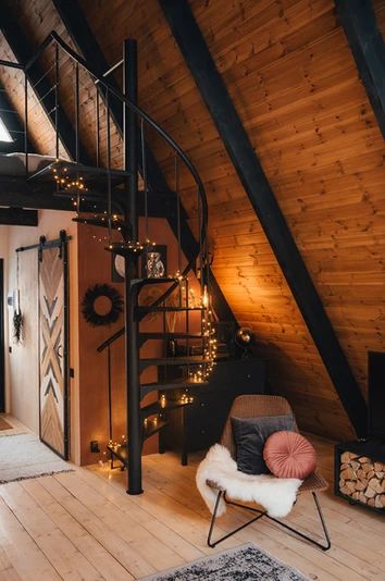 a living room with a spiral staircase next to a fire place