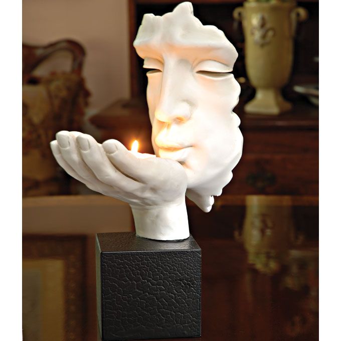 a white statue with a lit candle in it's mouth