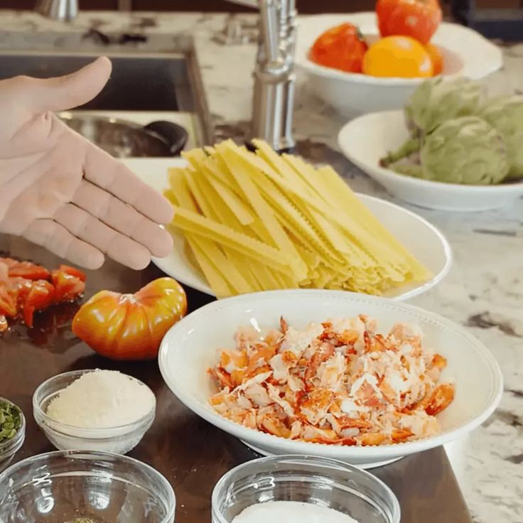 a person is preparing food in bowls on a counter top with other dishes around them