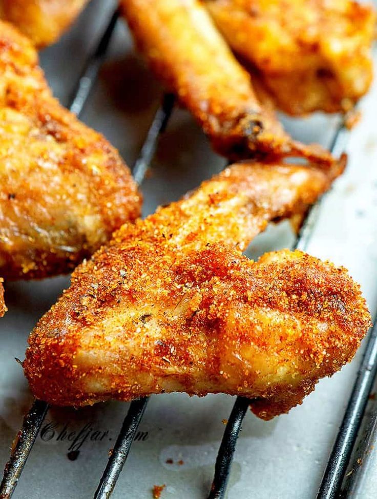 chicken wings are cooking on the grill