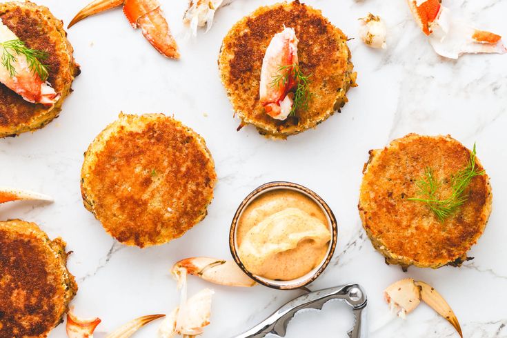 crab cakes with dipping sauce on a marble table