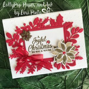 a handmade christmas card with red and white paper on it, surrounded by green leaves