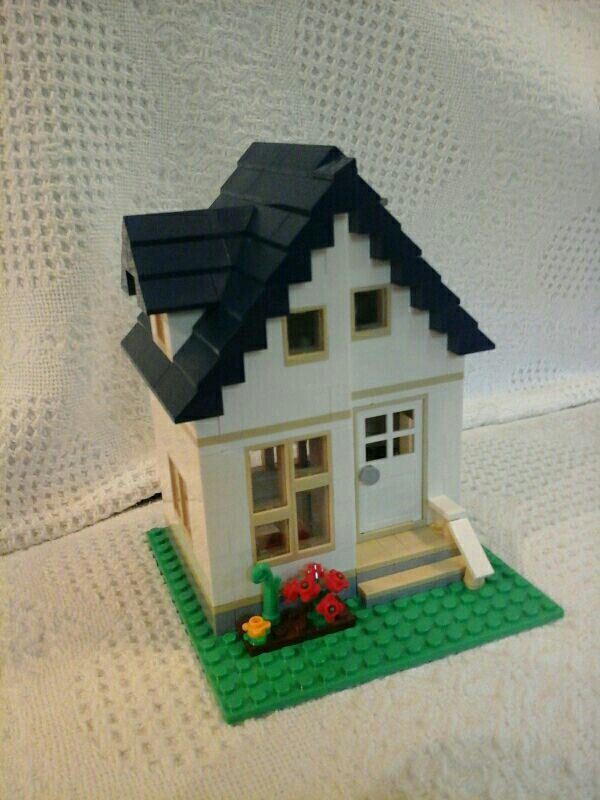 a toy house made out of legos on a bed