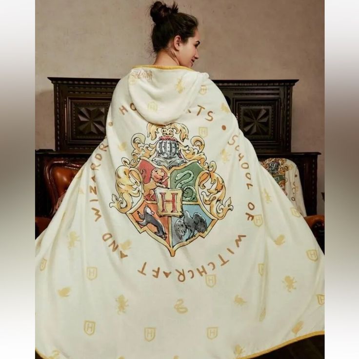 a woman wearing a white cloak with hogwart on it