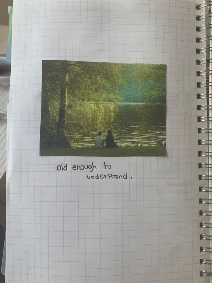 an open notebook with the words old enough to understand on it and a photo of two people sitting in a lake