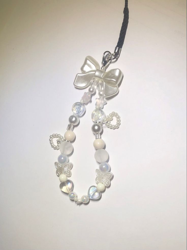 a necklace with pearls and a bow on it