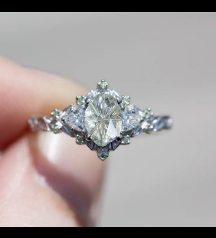 a woman's hand holding an engagement ring