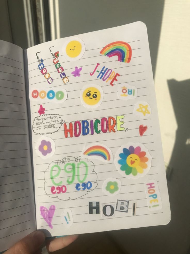 someone holding up a notebook with stickers on it