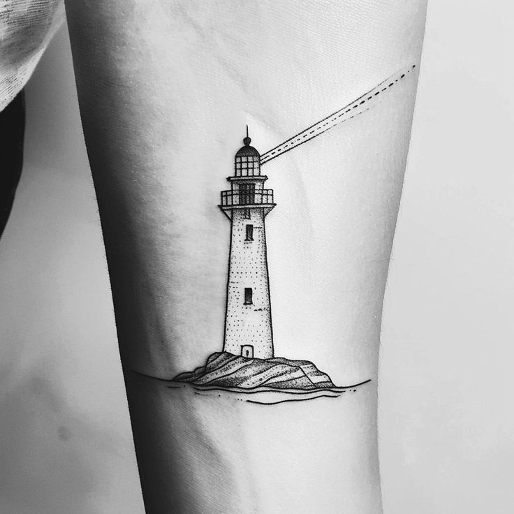 a black and white lighthouse tattoo on the arm