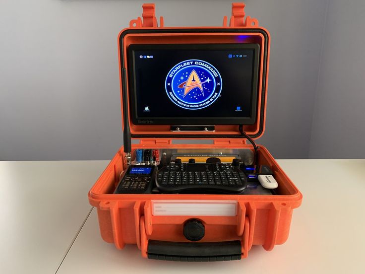 an orange case with a keyboard and mouse in it on top of a white table