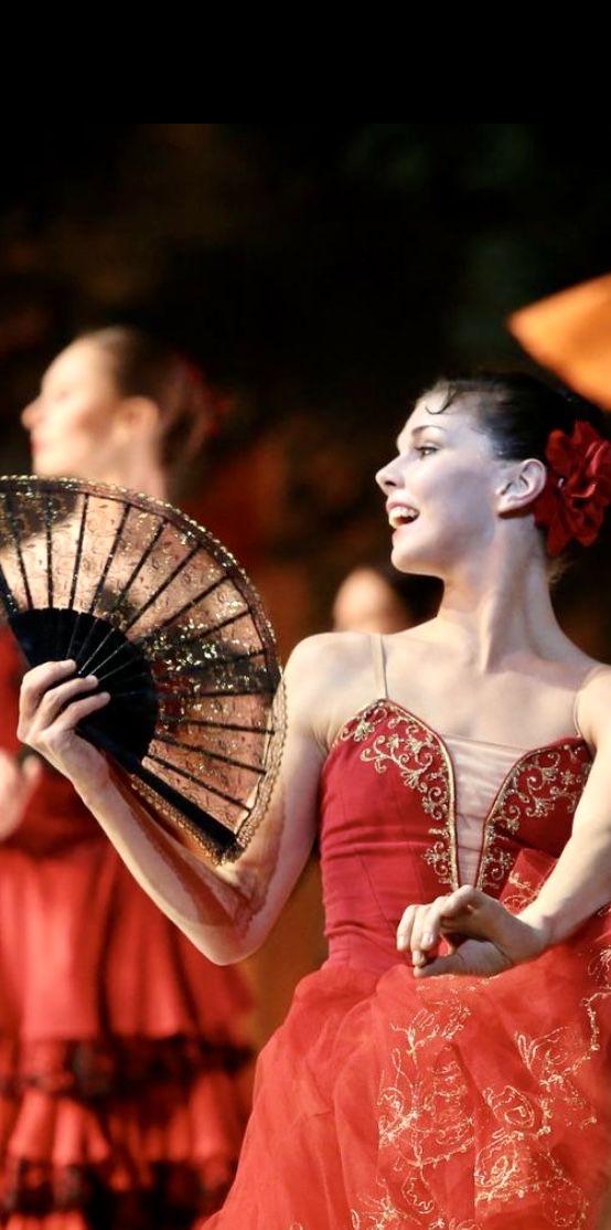 a woman in a red dress holding a fan