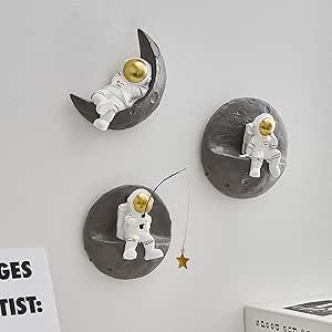 there are three little astronauts on the moon wall clocks, and one is holding a string