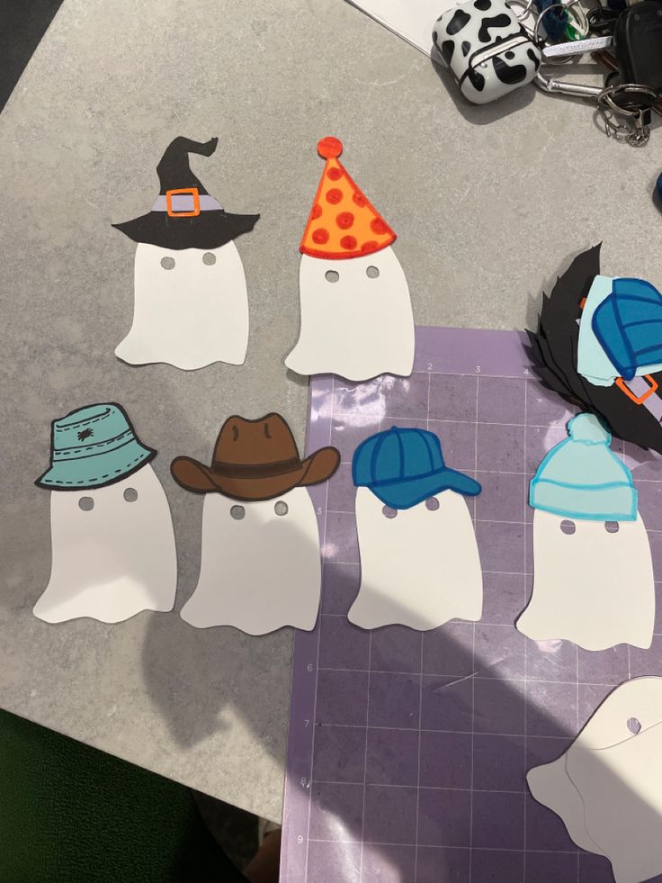 paper cut out of penguins with hats on them sitting on top of a piece of paper