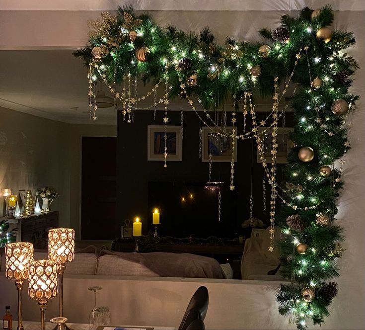 a mirror with christmas decorations and candles on it's side in a living room