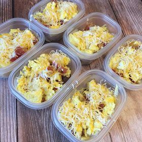 six plastic containers filled with food sitting on top of a wooden table covered in cheese