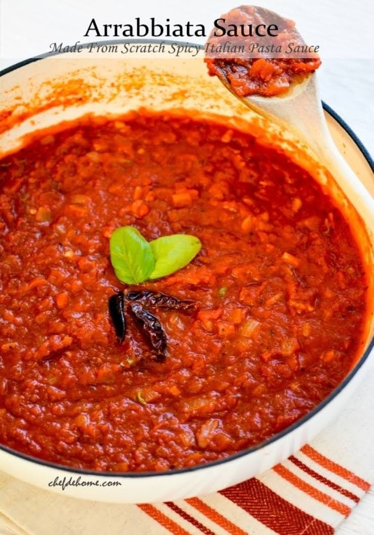 a pot filled with red sauce on top of a table