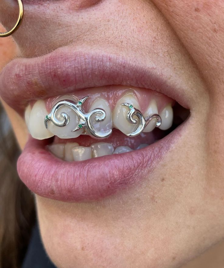 a close up of a woman's mouth with braces and piercings on it