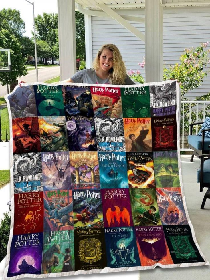 a woman holding up a harry potter quilt