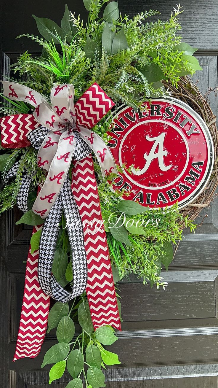 a wreath with the letter a on it and a ribbon attached to it is hanging on a door