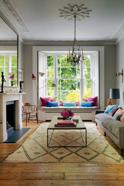 a living room filled with furniture and a fire place in front of a large window