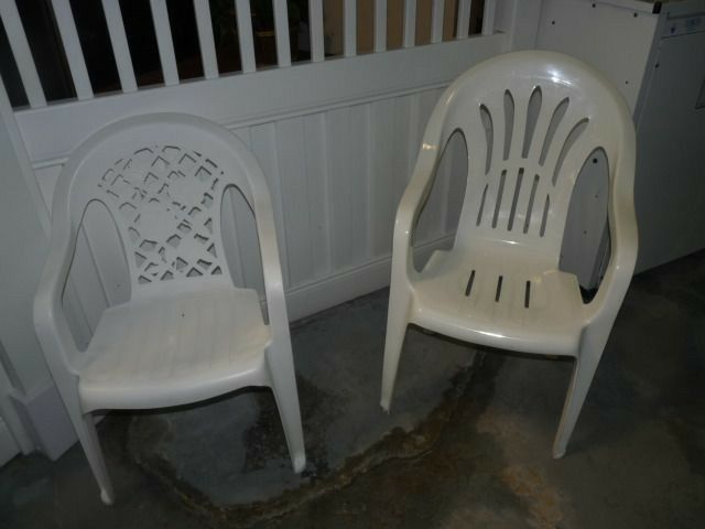 two white plastic chairs sitting next to each other