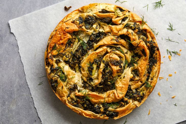 an overhead view of a pizza with spinach and other toppings on paper towel