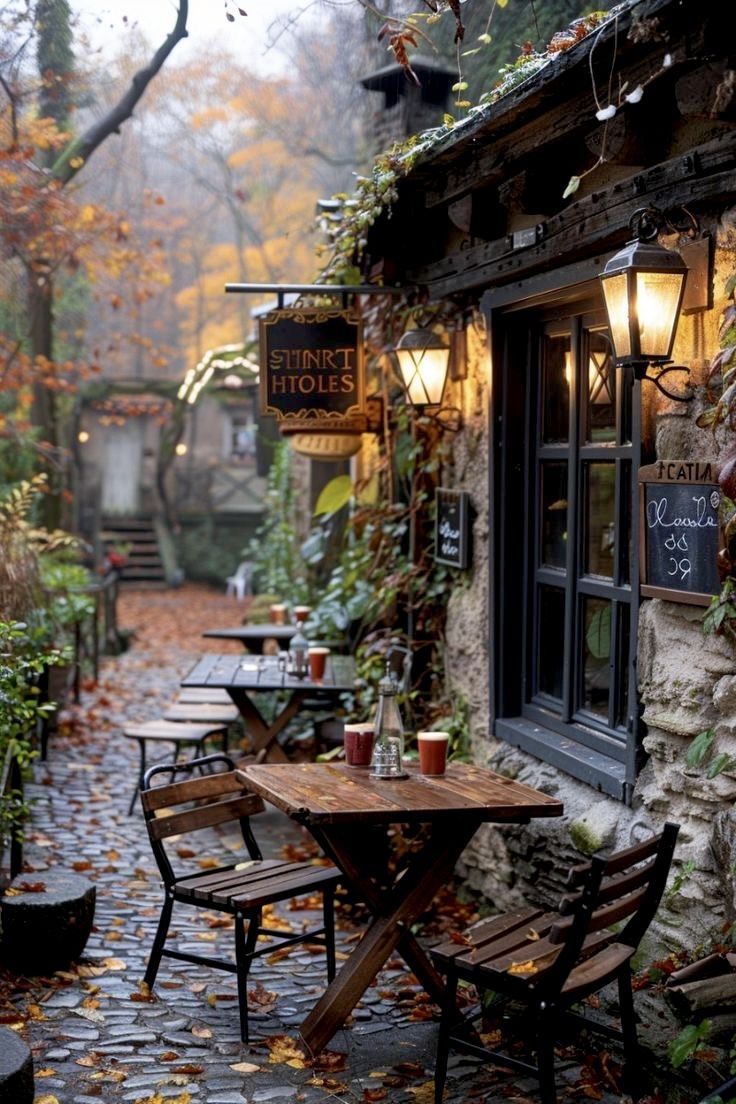 the outside of a restaurant with tables and chairs in front of it on a cobblestone path