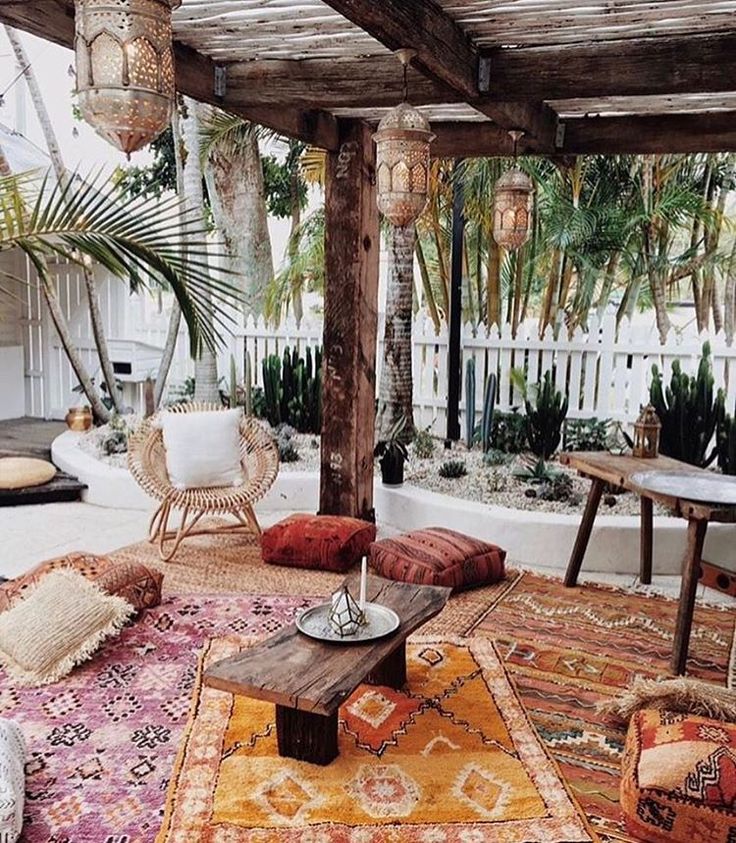 a living room with lots of furniture and plants in the back ground, along with potted palm trees