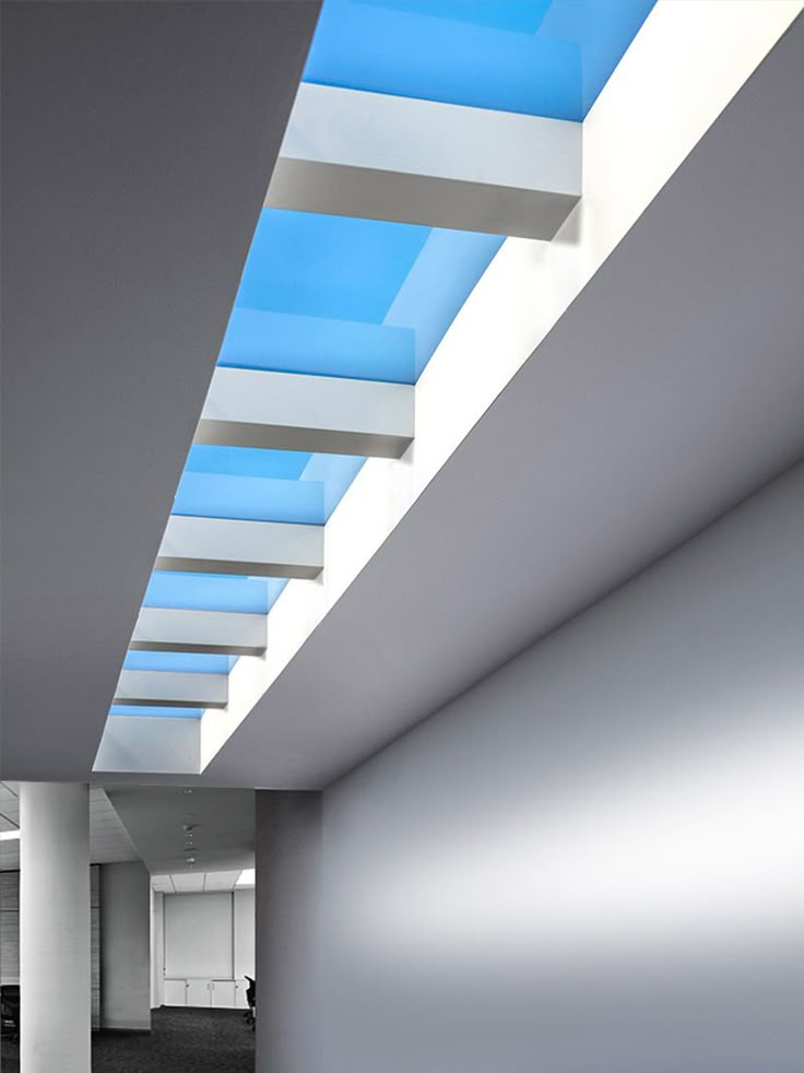 an empty room with blue skylights and white walls