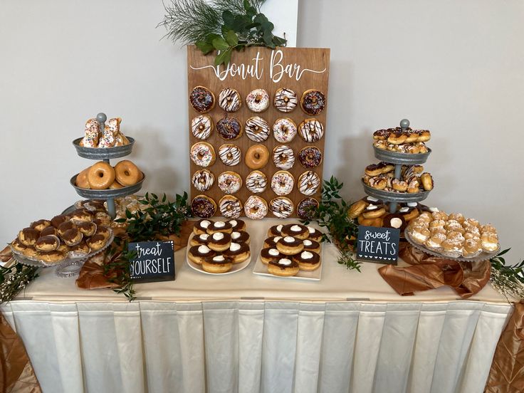 a table topped with lots of donuts and pastries