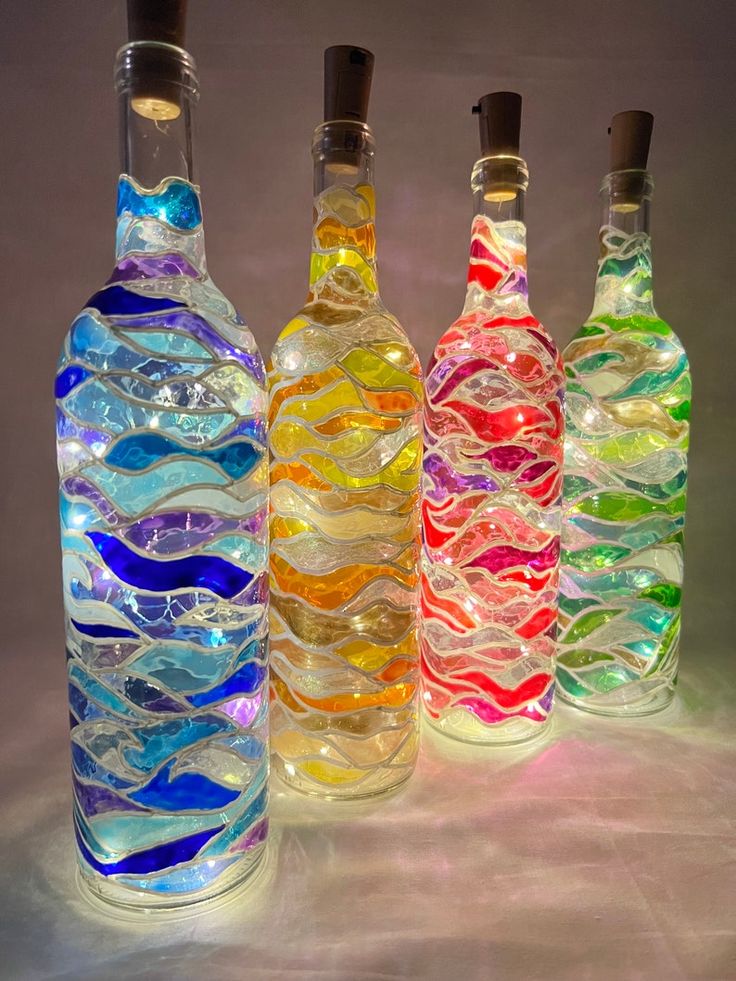 three bottles with different colored glass in them