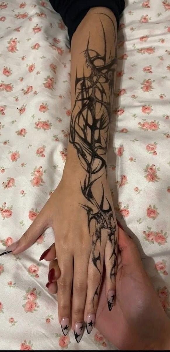 a woman's arm and hand with tattoos on it