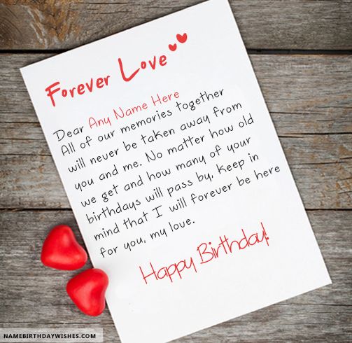 two red hearts sitting on top of a piece of paper next to a happy birthday card