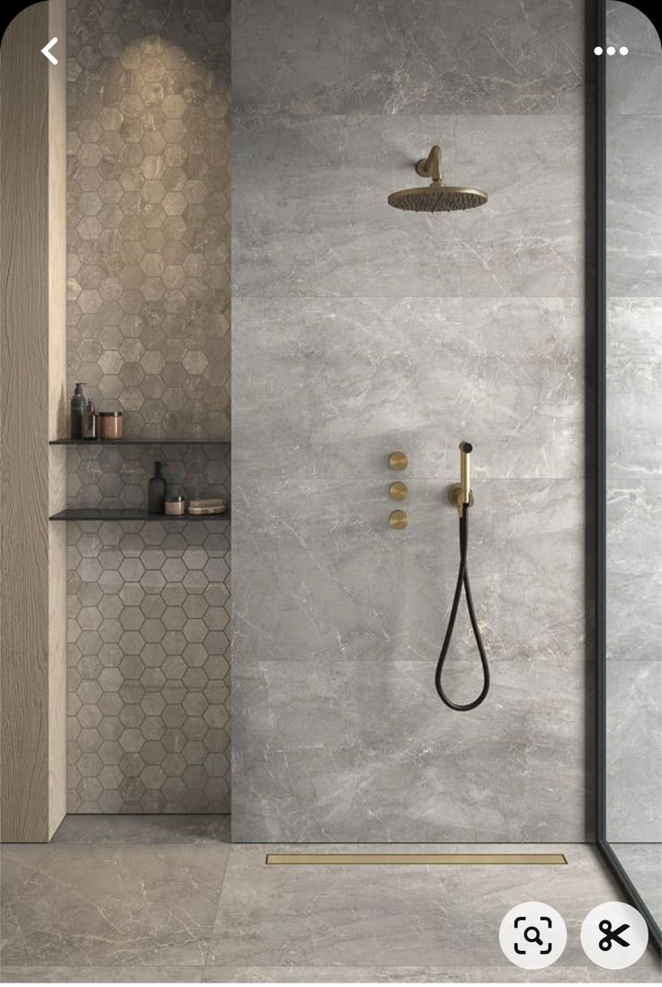 a bathroom with a walk in shower and hexagonal tiles on the walls, along with shelves