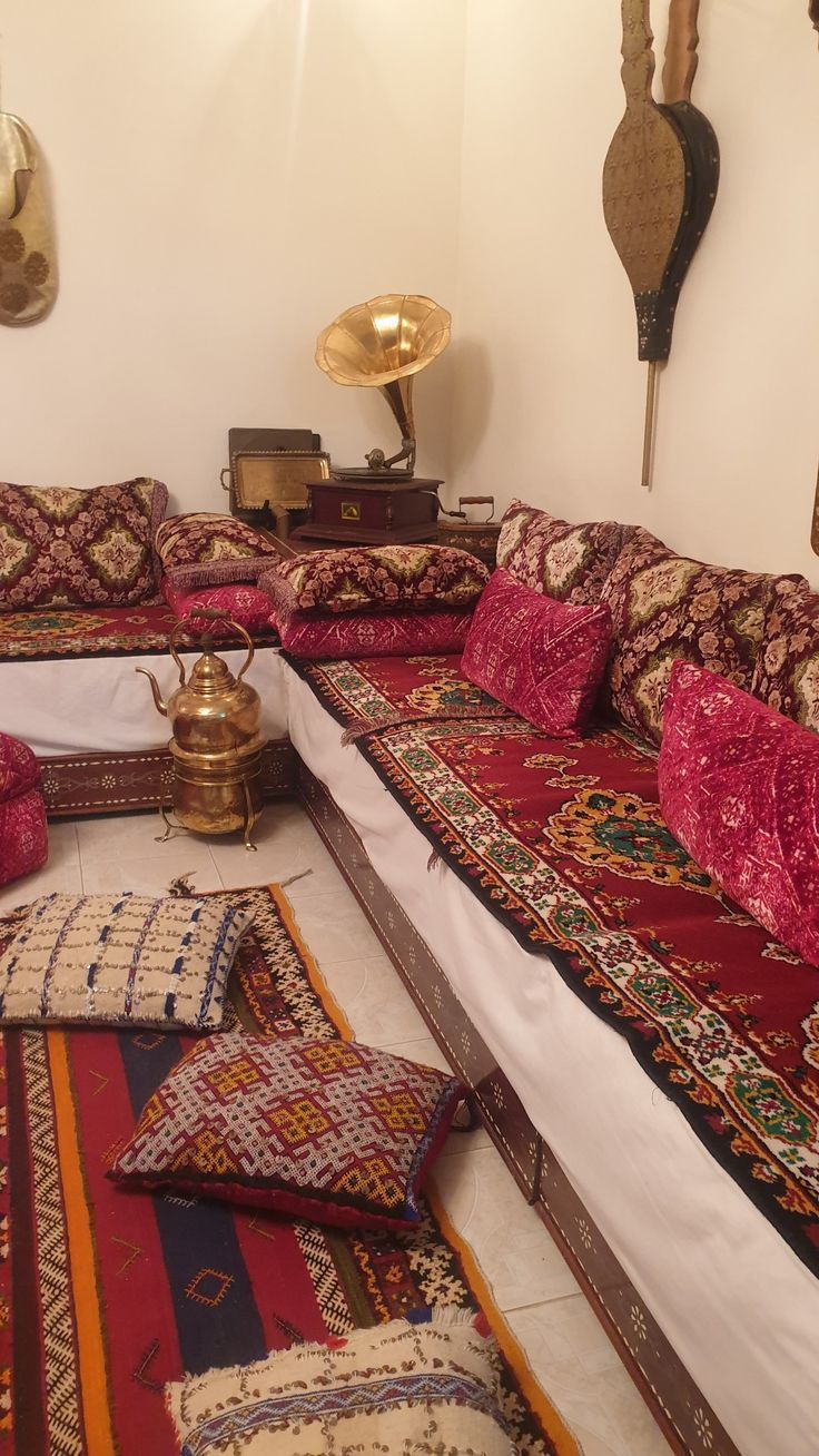 a living room filled with lots of pillows and rugs on top of each other