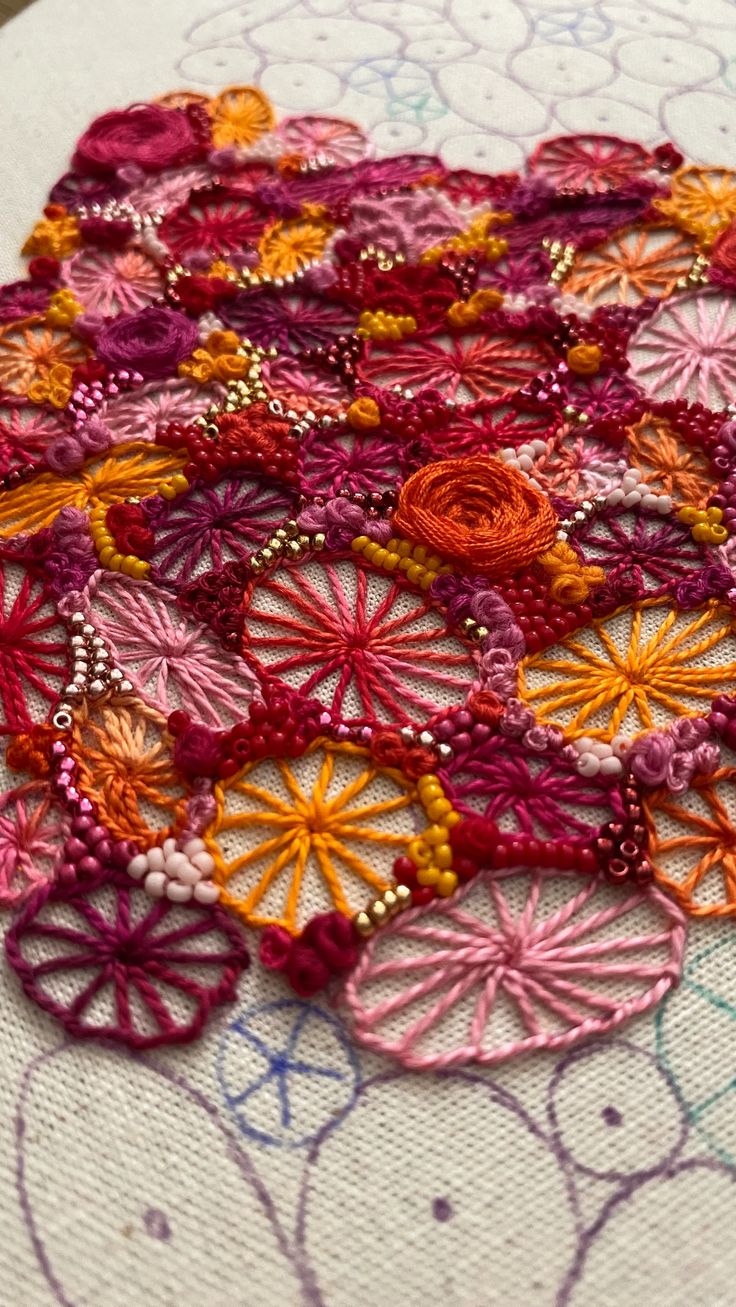 a close up of a piece of embroidery on a table cloth with bead work