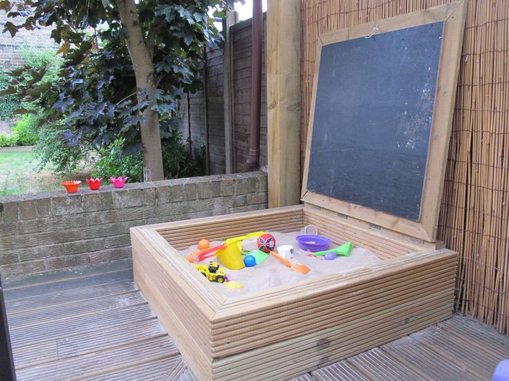 an outdoor play area with sand and toys