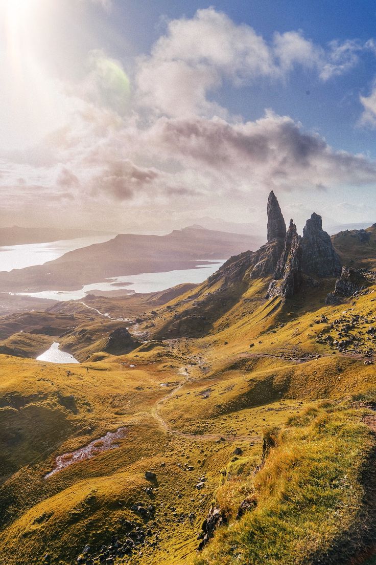 the sun shines brightly on an alpine landscape with mountains and lakes in the distance