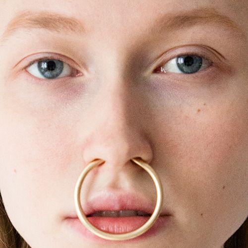 a close up of a person with a nose ring in front of their face,