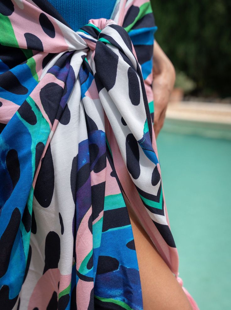 Meet the Melanie Pareo, your go-to layer for beach days and poolside lounging. Generously sized and crafted from soft, breathable rayon, it’s easy to tie and re-tie as you move from sun to shade. Wear it as a sarong skirt, knot it as a chic cover-up, or wrap it around your waist—this versatile pareo is designed for wherever the day takes you. Finished with tassel trim for a touch of movement, it’s a must-have for every woman who’s in and out of the water and always on the go.Pairs perfectly with Summer Tied Swimwear For Pool, Beachy Sarong For Poolside Spring, Beach Swimwear With Tied Details, Summer Tied Swimwear For Beach Party, Casual Beach Cover-up With Tie-side Bottom, Tied Swimwear For Summer, Casual Tie-side Bottom Beach Cover-up, Casual Sarong For Poolside And Beach Season, Summer Tied Swimwear For Beach Season