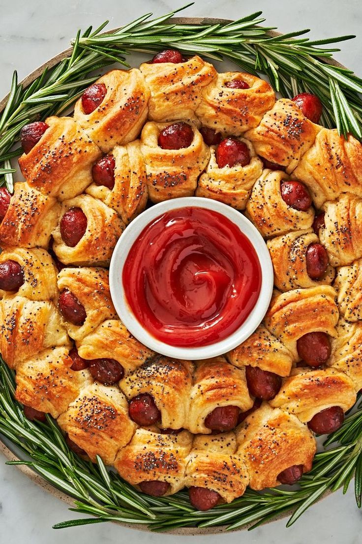 a platter filled with pigs in a blanket and ketchup