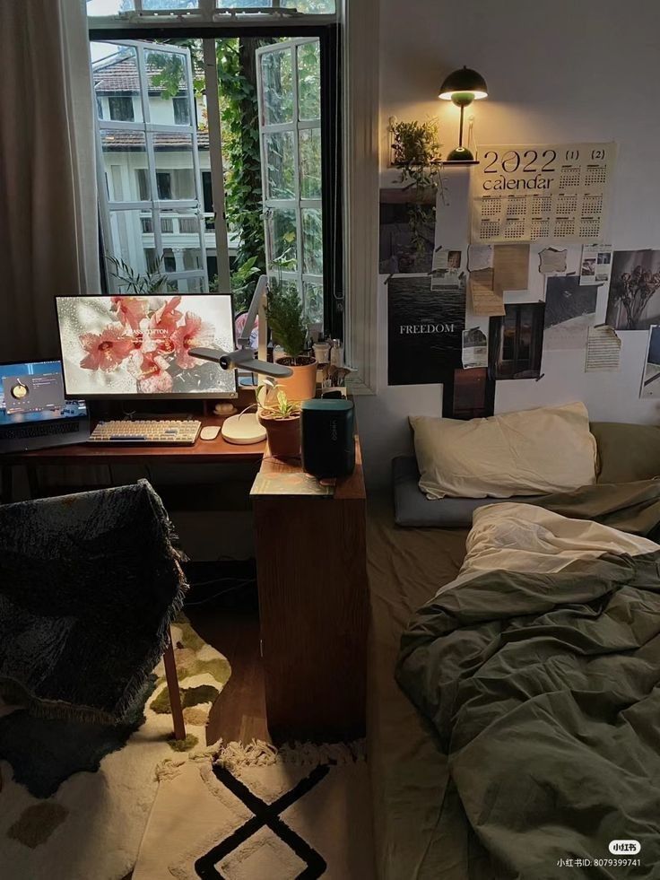 a bedroom with a bed, desk and computer on the table in front of a window