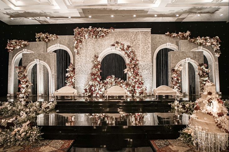 an elaborately decorated stage set up with flowers and candles for a wedding or special event