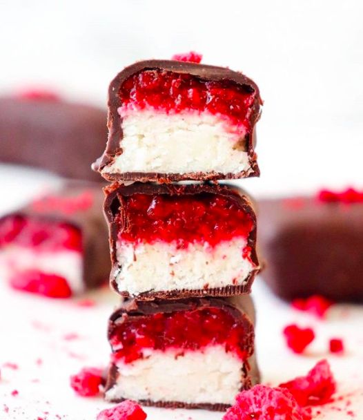 three pieces of chocolate with raspberry filling on top