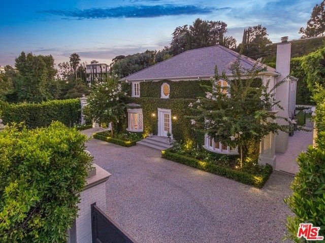 this is an aerial view of the house at dusk, with its driveway and landscaping